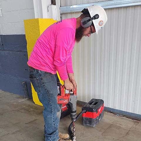 EnviroTrac technician using a jackhammer to install a vapor probe for an SSDS.